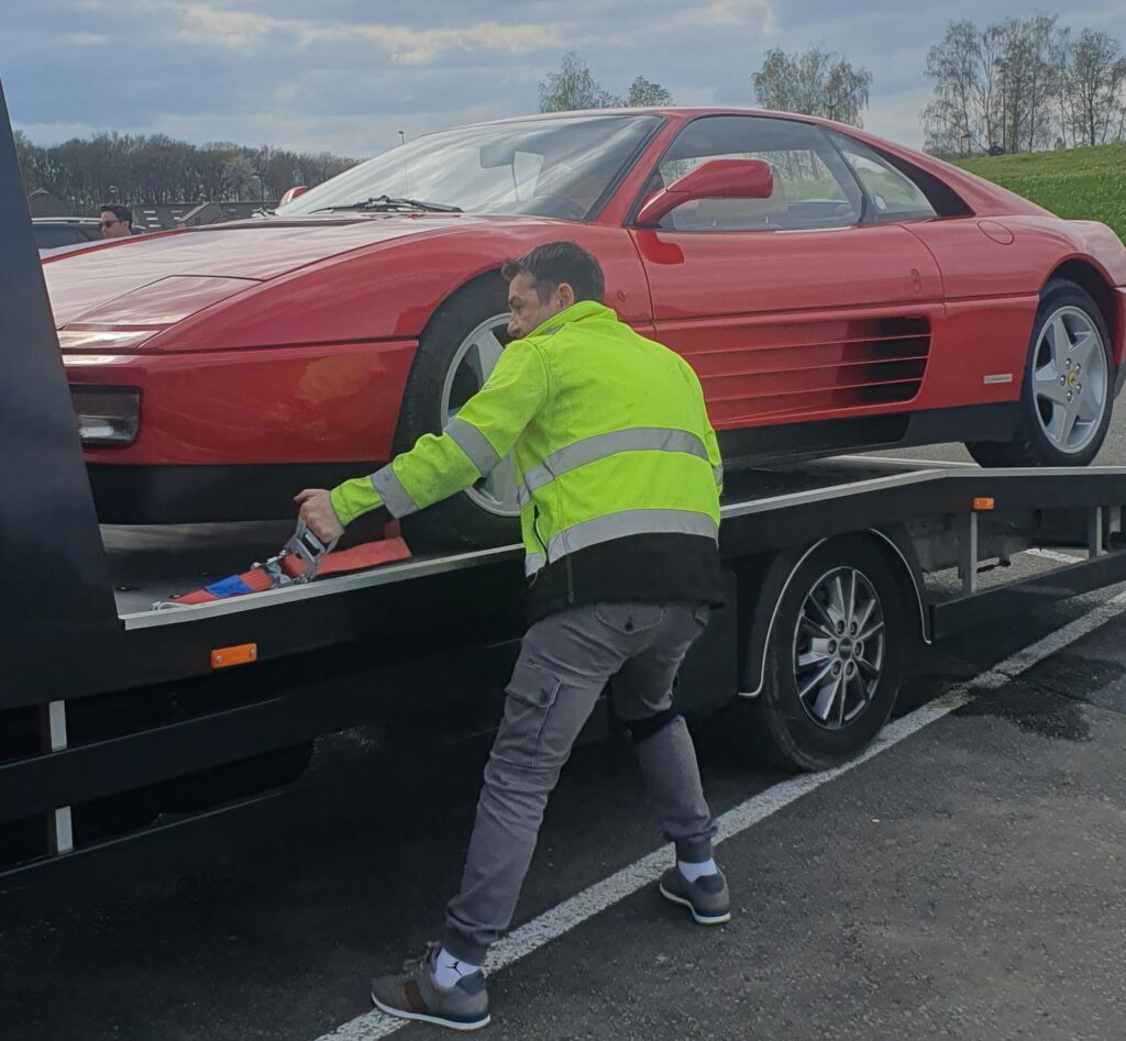 Dépanneur en train d’attacher une Ferrari sur une dépanneuse