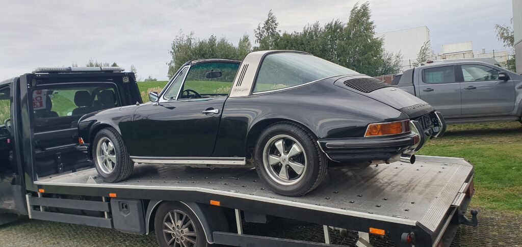 Dépanneur en train d’attacher une ancienne Porsche targua sur une dépanneuse